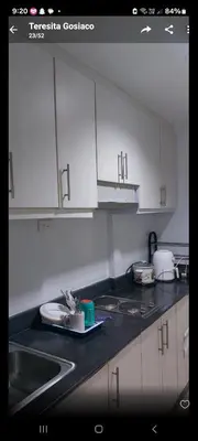 a kitchen counter with white cabinets and a sink at Sea Residences By Queen in Manila
