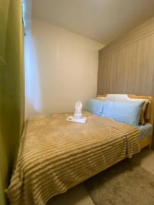 a bedroom with a bed with a hat on it at The Residence Suite in Manila