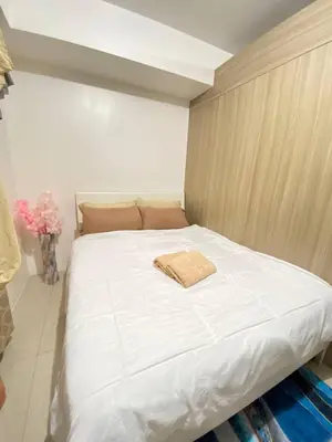 a white bed with a towel on it in a room at The Residence Suite in Manila