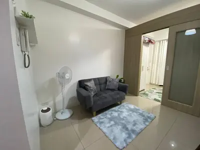 a living room with a couch and a fan at The Residence Suite in Manila