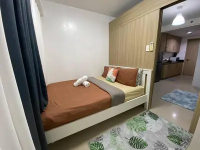 a bedroom with a bed with a teddy bear on it at The Residence Suite in Manila