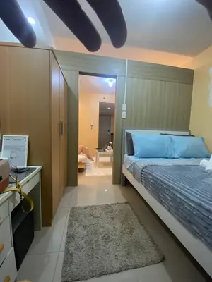 a bedroom with a large bed and a bathroom at The Residence Suite in Manila
