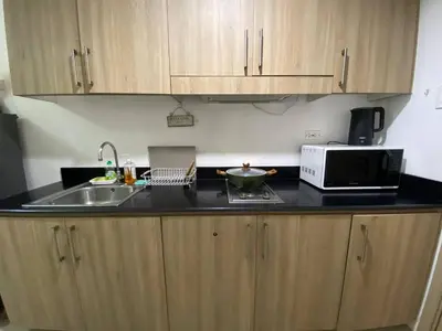 a kitchen with a sink and a microwave at The Residence Suite in Manila