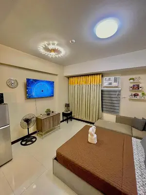 a large room with a bed and a living room at 101 Newport Blvd - SkyBison Aerie Condo Across NAIA T3 in Manila
