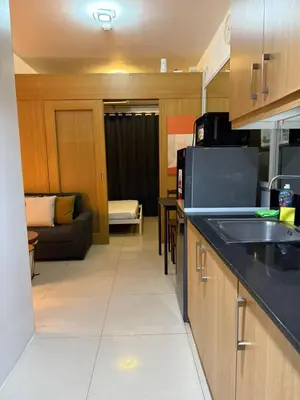 a kitchen with a sink and a couch in a room at Cozy, budget-friendly stay for families and friends at Shell Residences by ONE Guest Place in Manila