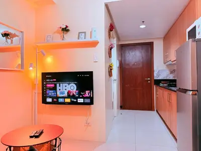 a kitchen with a tv on the wall and a table at Cozy, budget-friendly stay for families and friends at Shell Residences by ONE Guest Place in Manila