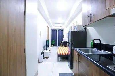 a small kitchen with a sink and a refrigerator at Apartment near MOA & Airport in Manila