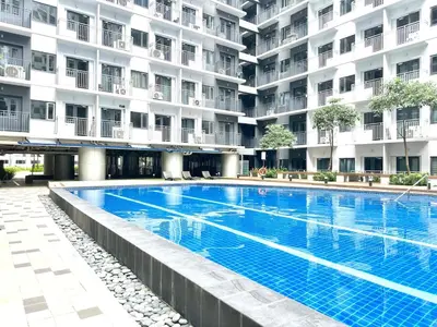 a large swimming pool in front of a building at Apartment near MOA & Airport in Manila