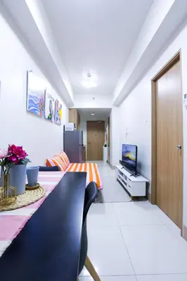 a living room with a table and a television at Apartment near MOA & Airport in Manila