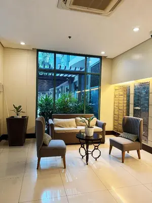 a lobby with a couch and two chairs and a table at Kai cabins NAIA 3 walking distance Newport City Pasay in Manila