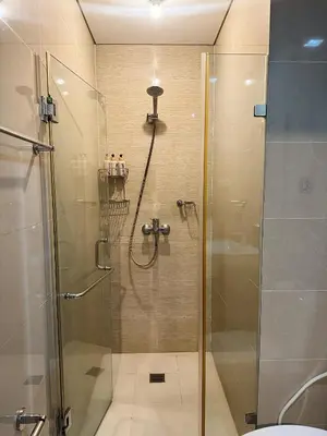 a bathroom with a shower with a glass door at Kai cabins NAIA 3 walking distance Newport City Pasay in Manila