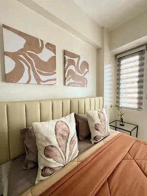 a bedroom with a bed with two paintings on the wall at Kai cabins NAIA 3 walking distance Newport City Pasay in Manila
