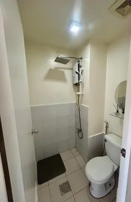 a bathroom with a toilet and a shower at The View Studio in Urban Deca Tower EDSA in Manila