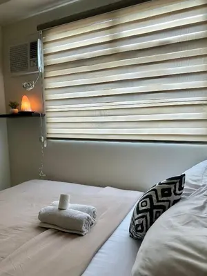 a bedroom with a window with a towel on a bed at The View Studio in Urban Deca Tower EDSA in Manila