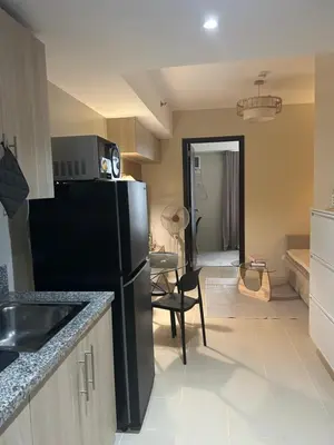 a kitchen with a black refrigerator and a dining room at Kasara Urban Residences in Pasig City - Solmera Cove in Manila