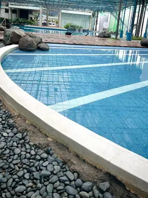 a swimming pool with rocks around it at Kasara Urban Residences in Pasig City - Solmera Cove in Manila