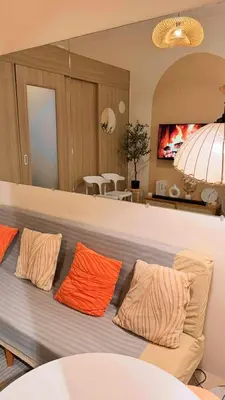a couch with three orange pillows in a living room at Family Room Staycation Shore Residences Near Mall of Asia and Airport Adjacent Units - Perfect for Groups in Manila
