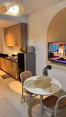 a kitchen with a table and some chairs and a table and a kitchen at Family Room Staycation Shore Residences Near Mall of Asia and Airport Adjacent Units - Perfect for Groups in Manila