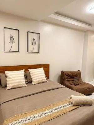 a bedroom with two beds and a chair at Kai cabins SELF CHECK IN NEAR NAIA 1 & 2 in Manila