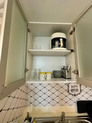 a kitchen with a sink and a shelf with utensils at Stay at Downtown Suite 2 in BGC, Taguig City in Manila