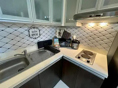 a kitchen counter with a sink and a stove at Stay at Downtown Suite 2 in BGC, Taguig City in Manila