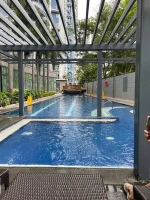 a large pool with blue water in a building at Classy BGC Condo City View Pool Gym Sauna in Manila