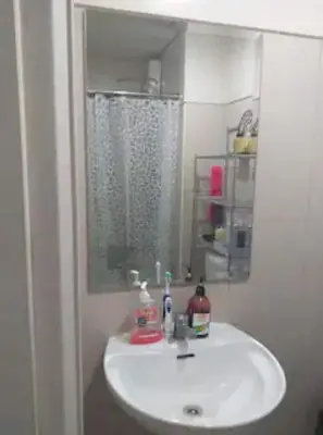 a bathroom with a white sink and a mirror at MOA Staycation - Shell Condo in Manila