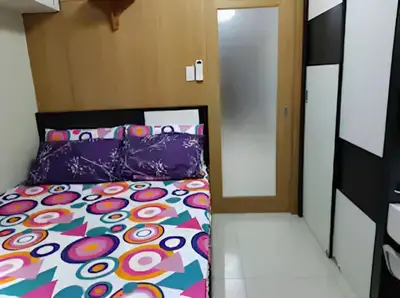 a bedroom with a bed with a colorful bedspread at MOA Staycation - Shell Condo in Manila