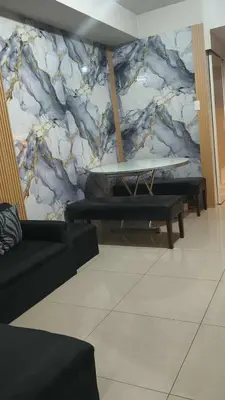 a room with a surfboard on a marble wall at MOA Staycation - Shell Condo in Manila