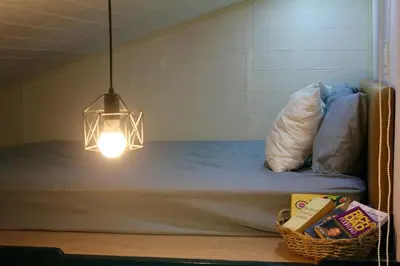 a room with a bed with a light and a basket at Kamia Tiny Rest House in Sampong