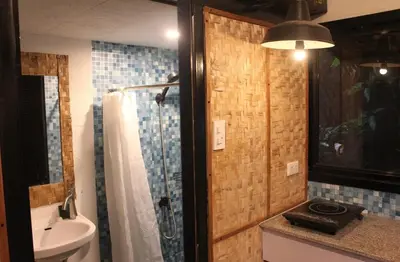 a bathroom with a shower and a sink at Kamia Tiny Rest House in Sampong