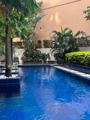 a swimming pool with blue water in a building at La Casa Zen - Cozy Studio with private Wi-Fi, complimentary access to Fitness Centre, swimming pool and stunning city view located near the CBD of Ortigas, Makati, BGC in Manila