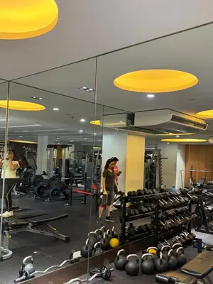 a woman is taking a picture in a gym at La Casa Zen - Cozy Studio with private Wi-Fi, complimentary access to Fitness Centre, swimming pool and stunning city view located near the CBD of Ortigas, Makati, BGC in Manila