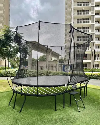 an empty trampoline on the grass in a city at Deluxe Cozy Room Near BGC & Ortigas with Balcony & City View in Manila