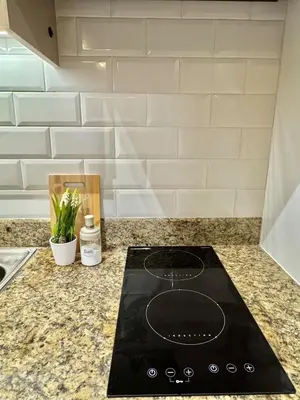 a black stove top on a counter in a kitchen at Deluxe Cozy Room Near BGC & Ortigas with Balcony & City View in Manila