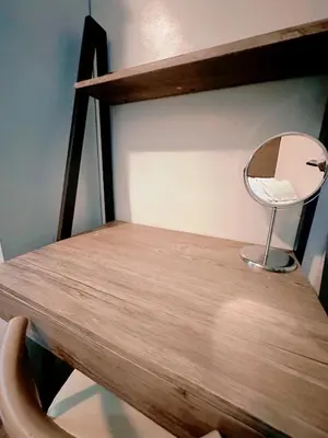 a wooden desk with a mirror and a chair at Makati Stay Ph in Manila