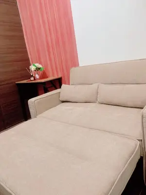 a room with a bed and a table with a flower vase at Makati Stay Ph in Manila