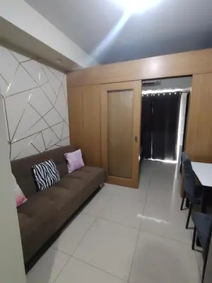 a living room with a couch and a table at Shell residences Near Moa Japs staycation in Manila
