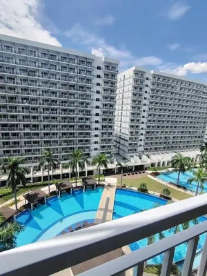 a view of a large apartment building with a swimming pool at Shell residences Near Moa Japs staycation in Manila