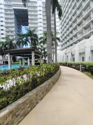 a walkway in the middle of a city with tall buildings at Shell residences Near Moa Japs staycation in Manila
