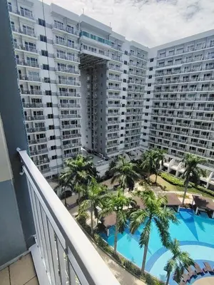 a balcony view of a large apartment building with a swimming pool at Shell residences Near Moa Japs staycation in Manila