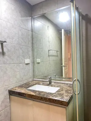 a bathroom with a sink and a mirror at Monarch Parksuites in Manila