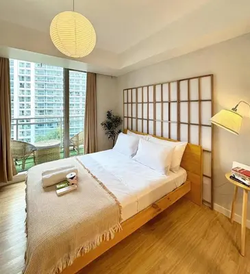a bedroom with a large bed and a large window at Boracay by SIA in Manila