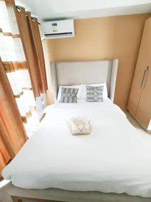 a bedroom with a white bed with a basket on it at Boracay by SIA in Manila