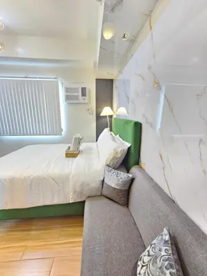 a bedroom with a bed and a couch at RM South Staycation in Biñan