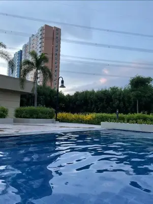 a swimming pool with blue water in a city at RM South Staycation in Biñan