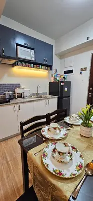 a kitchen with a table with two plates on it at RM South Staycation in Biñan