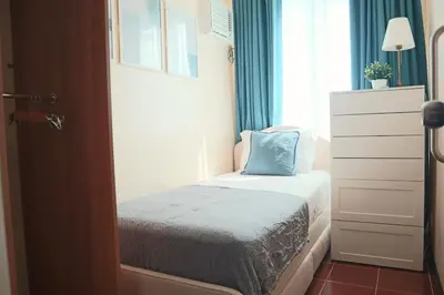a small bedroom with a bed and a window at 2BR Condo - Makati CBD, Sunset Views, 20mins to NAIA in Manila