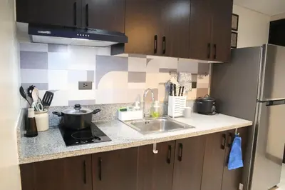 a kitchen counter with a sink and a stove at 2BR Condo - Makati CBD, Sunset Views, 20mins to NAIA in Manila