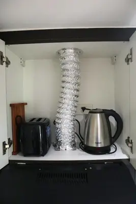 a vase sitting on top of a stove with a tea kettle at 2BR Condo - Makati CBD, Sunset Views, 20mins to NAIA in Manila